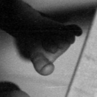 Infant lying in a wooden crib.