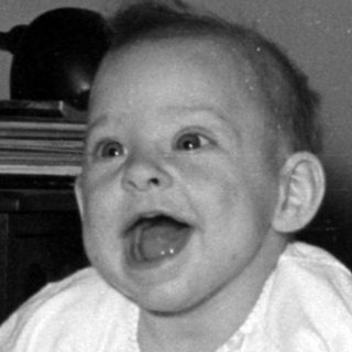 Baby lying on a bed in a domestic room.