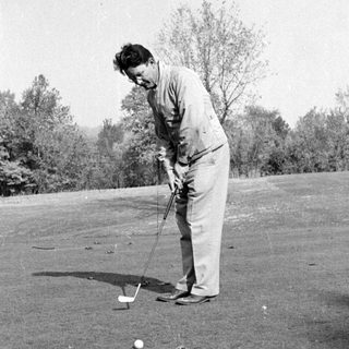Man playing golf on a grassy course.