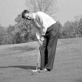 Man preparing to hit a golf ball.