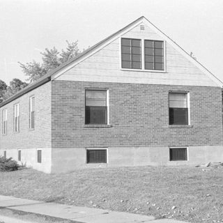 Small brick building with a gabled roof.