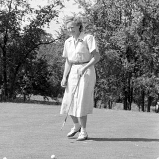 Three people on a golf course green.