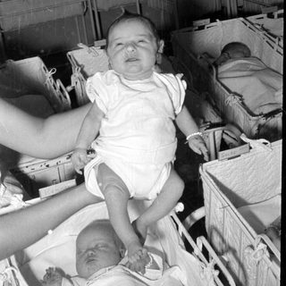 Infants in wicker bassinets in a nursery.