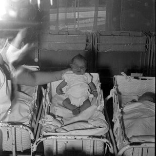 Infant in a hospital bassinet with 'Kummer' label.