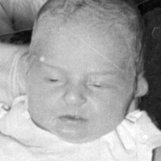 Infants in white bassinets in a nursery setting.