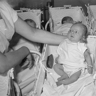 Three infants in hospital bassinets, black and white.