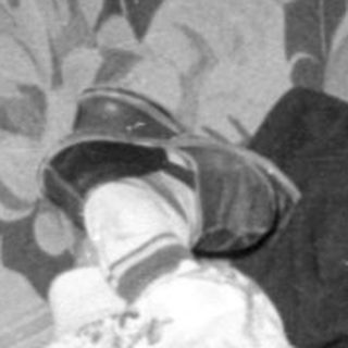 Two children lounging on a floral sofa.