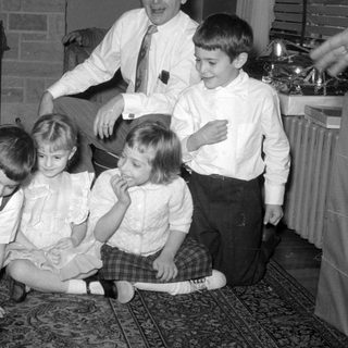 Four children and a man in a living room.