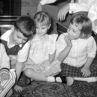 Four children and a man in a living room.