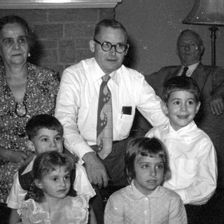 Group portrait of adults and children indoors.