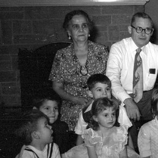 Group portrait of adults and children indoors.