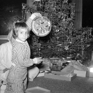 Child with educational game by a Christmas tree.