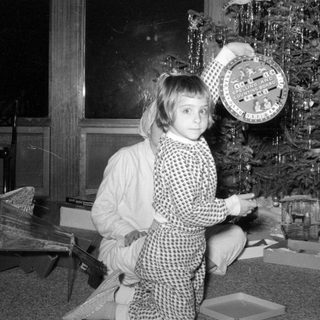 Child with educational game by a Christmas tree.
