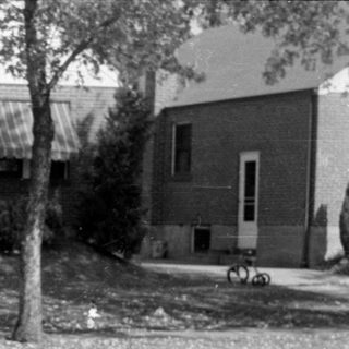 Woman holding a child in a residential neighborhood.
