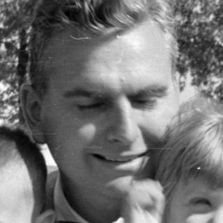 Man with two young children in a residential area.