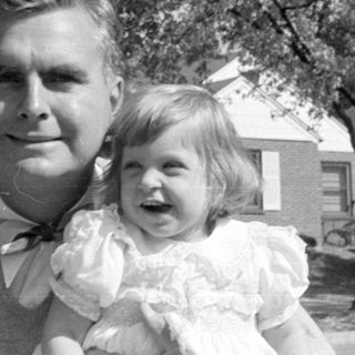 Man and two children in formal attire outdoors.