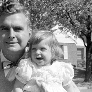 Man and two children in formal attire outdoors.