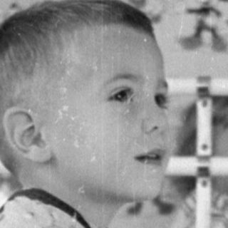 Boy on a rocking horse in a nursery.