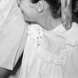Man in surgical mask holding a crying infant.