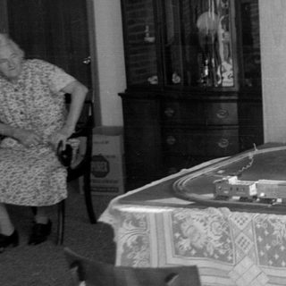 Boy playing with model train set on a table.