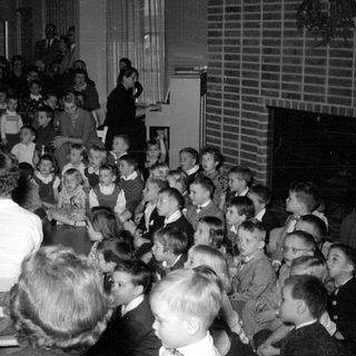 Children gathered for a performance or lesson with piano.