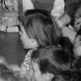 Children gathered for a performance or lesson with piano.