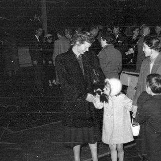 Group of people in formal coats at night.