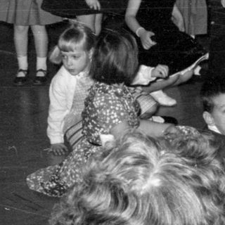 Children gathered near a fireplace with tinsel decorations.