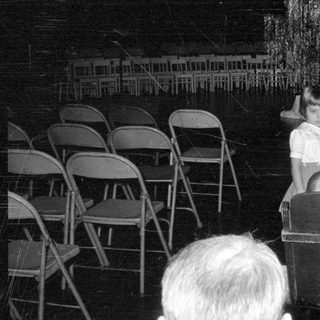 Man holding garment near a girl in a hall.
