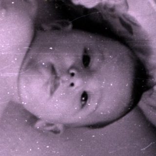 Infant in a diaper lying in a crib.