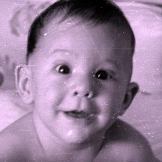 Infant lying in a floral patterned crib.