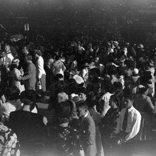 Crowd in formal attire in a dark indoor venue.