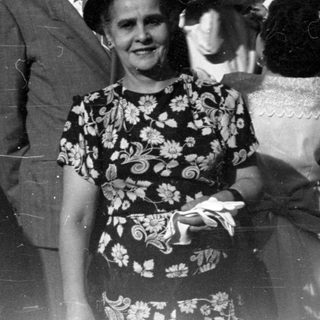 Group of people in formal attire by brick building.