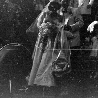 Wedding couple surrounded by a crowd of people.