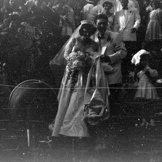 Wedding couple surrounded by a crowd of people.