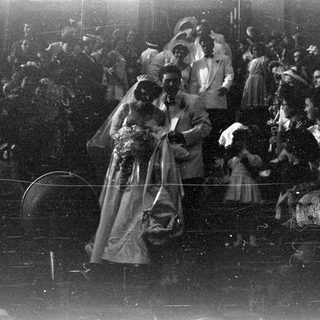 Wedding couple surrounded by a crowd of people.