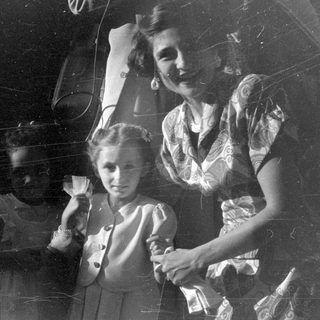 Woman and two young girls in vintage attire.