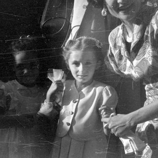 Woman and two young girls in vintage attire.