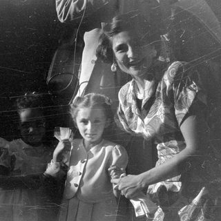 Woman and two young girls in vintage attire.