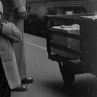 Child and man standing beside a train car.