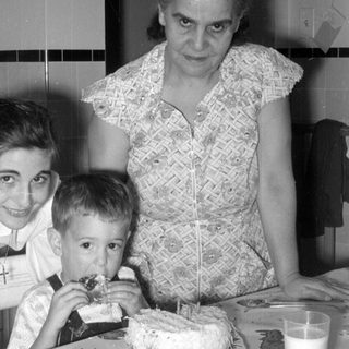 Woman, girl, and boy with a cake.