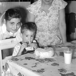 Woman, girl, and boy with a cake.