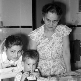 Woman, girl, and boy with a cake.