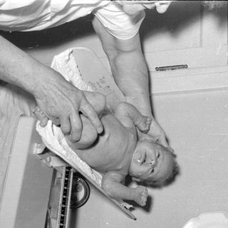 Baby being weighed on a medical scale.