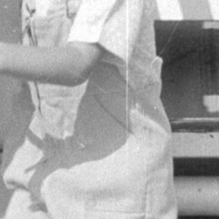 Child leaning over railing near TWA signage.