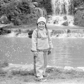 Child with snowshoe hat by waterfall