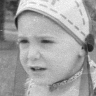 Child in headdress on car hood