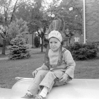 Child in chief costume on tire