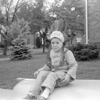 Child in chief costume on tire