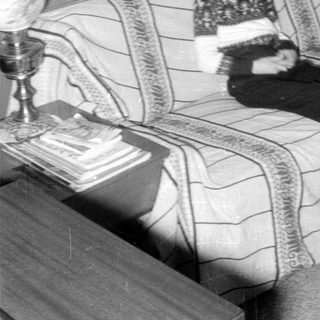 Child on couch indoors, mid-century